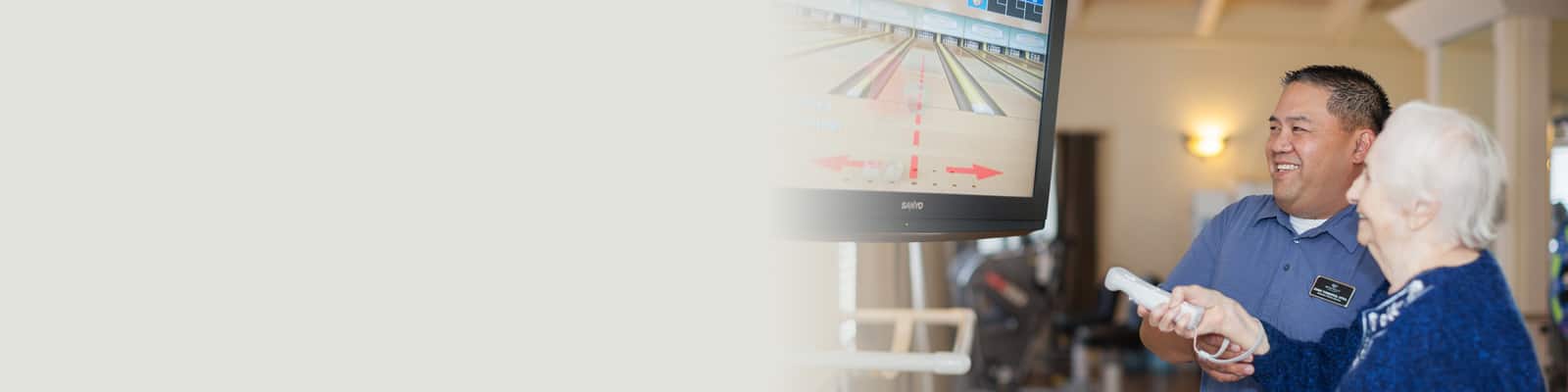 An elderly resident playing wii bowling at Roseville