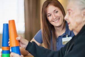 An occupational therapist helping a resident in the rehab gym at Roseville Care Center