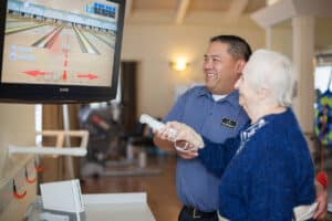 A rehab therapist with a resident using Wi at Roseville Care Center