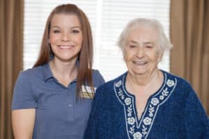A caregiver with a resident both smiling at Roseville Care Center