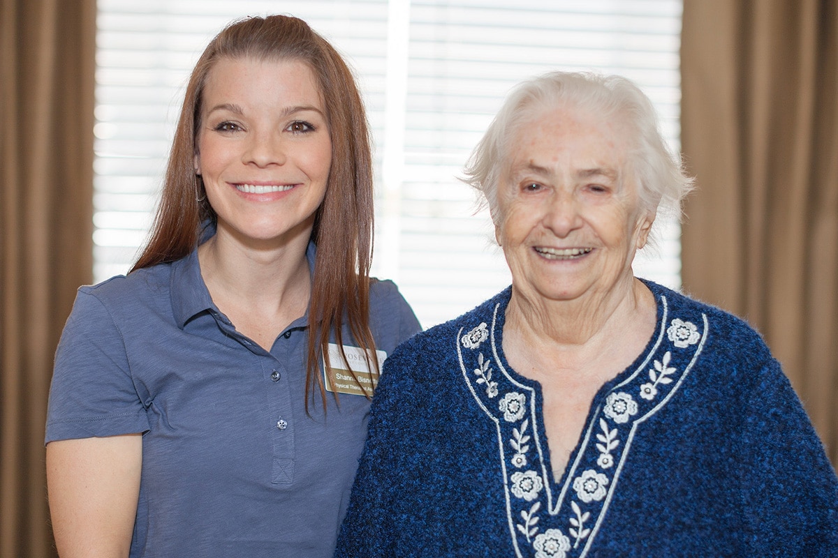 A caregiver with a resident both smiling at Roseville Care Center
