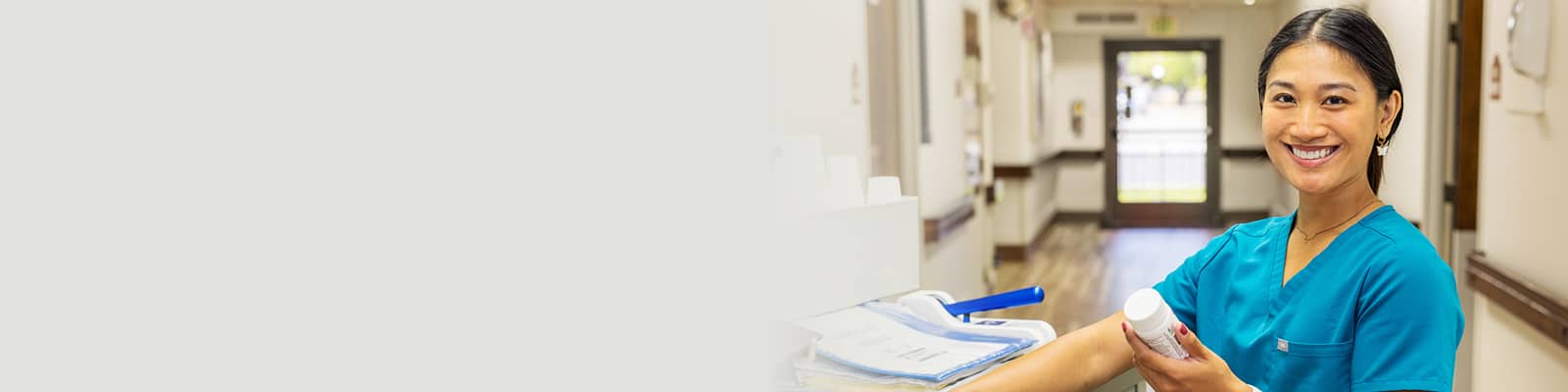 A nurse at a nurse's cart in the hallway at Roseville Care Center