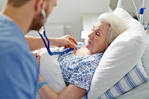 nurse listening to a patient's heartbeat